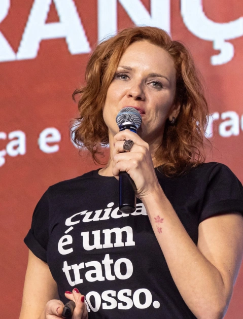 Juliana Bley falando ao microfone em um evento